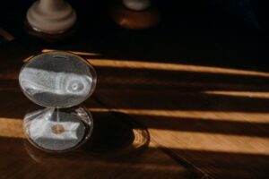 Peaceful sand timer casting shadows on a wooden table in warm morning sunlight.
