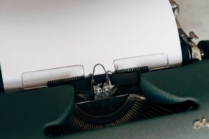 Close-up of a classic vintage typewriter with blank paper ready for typing.