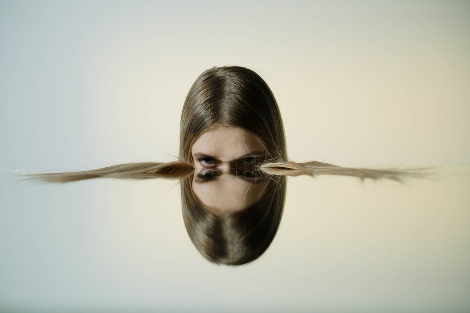 A conceptual portrait of a woman's reflection in water, offering tranquil and artistic vibes.